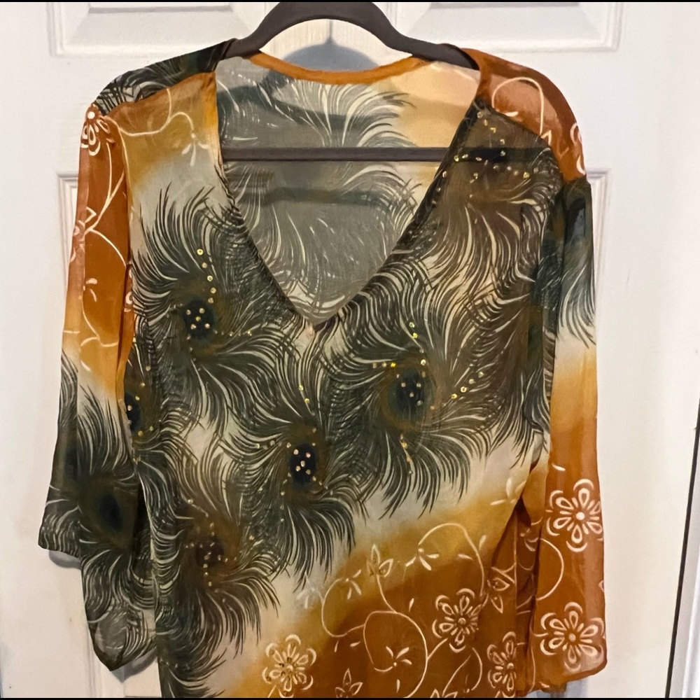 Sheer v-neck top with peacock print and sequins.